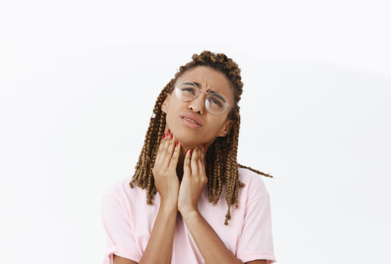 Mulher jovem sofrendo com cáseos amigdalianos